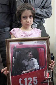 دختری که از میان آتش نجات داده شد، عکس فرشته ی نجاتش را در دست دارد