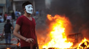 جوانی در تظاهرات با ماسک آشنای وندتا که دیگر در بیشتر تظاهرات در کشورهای مختلف به چشم می خورد