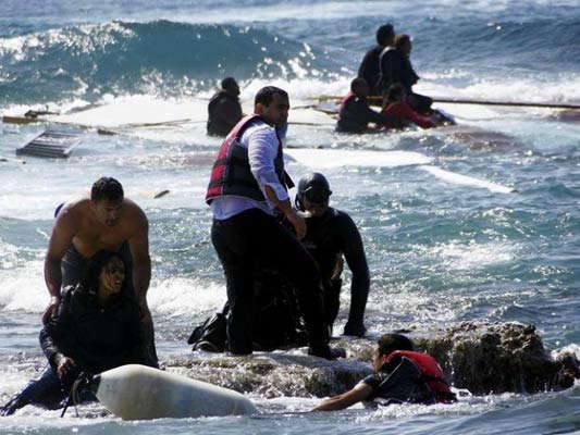 گارد ساحلی یونان نجات یافتگان قایق درهم شکسته را به ساحل می برد